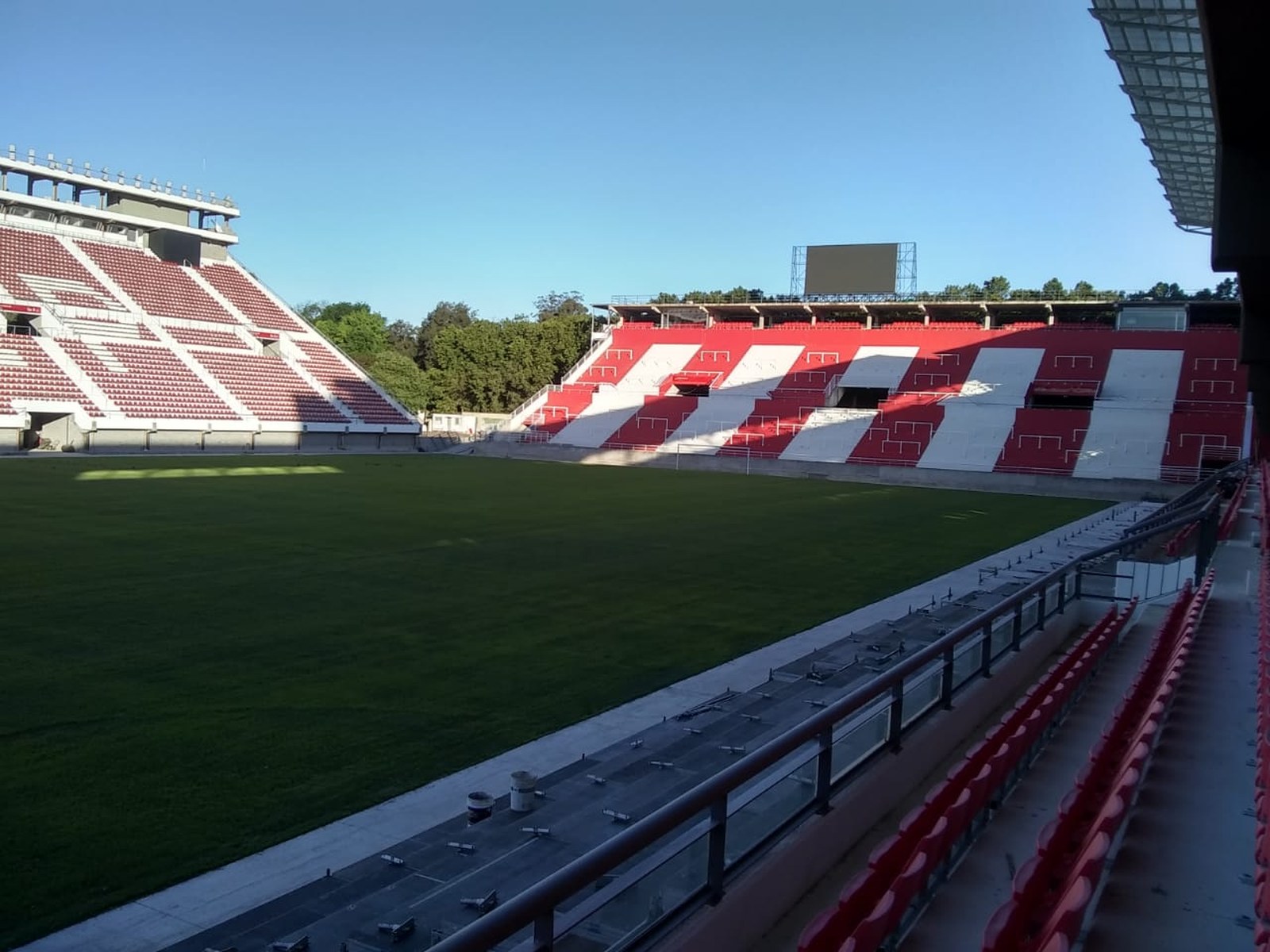 Tribunas rojas y blancas y el campo de juego del estadio Jorge Luis Hirschi de Estudiantes de La Plata, vacío, en su reinauguración