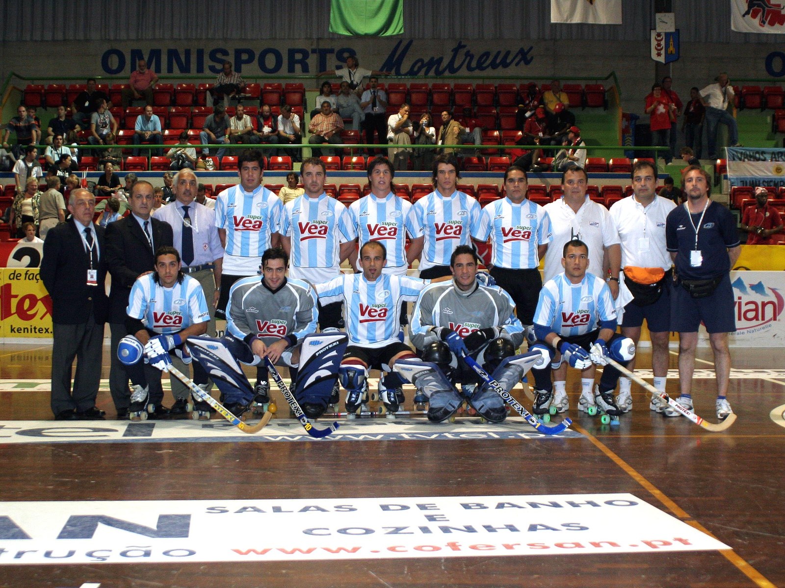 El plantel de la Selección Argentina de hockey sobre patines, con camiseta celeste y blanca, posa en la pista del estadio Omnisports de Montreux, en Suiza, junto al cuerpo técnico