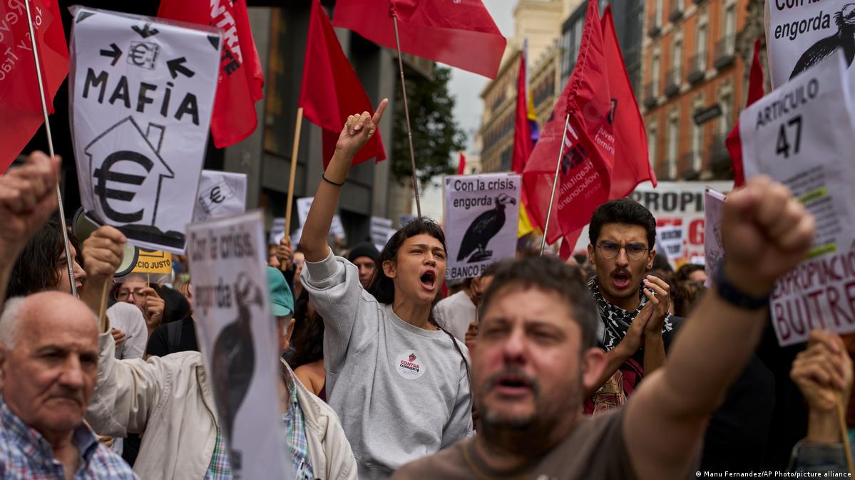 Manifestantes con pancartas y banderas rojas frente al Congreso de los Diputados en Madrid