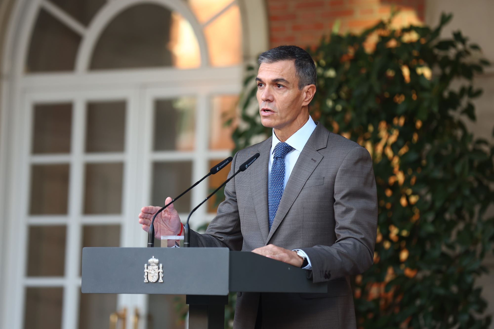 Pedro Sánchez habla en un atril con el escudo de España, en un patio del Palacio de la Moncloa