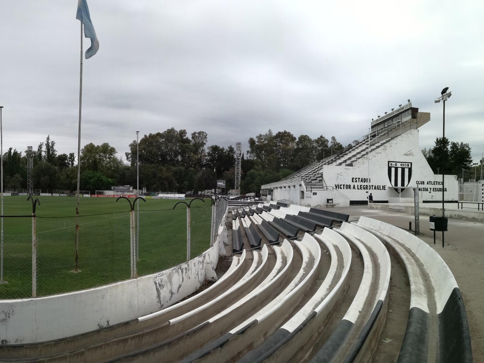 Foto de archivo (2017): tribunas y campo de juego del estadio Víctor Antonio Legrotaglie, de Gimnasia y Esgrima de Mendoza, con el escudo del club en la platea. Ozaru's Photos / Wikimedia Commons, CC BY-SA 4.0