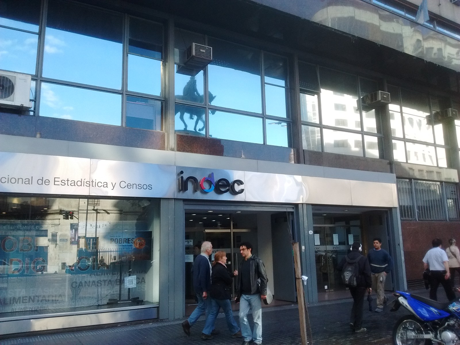 Entrada de la sede del INDEC en la Ciudad de Buenos Aires, con el cartel del Instituto Nacional de Estadística y Censos y gente en la vereda