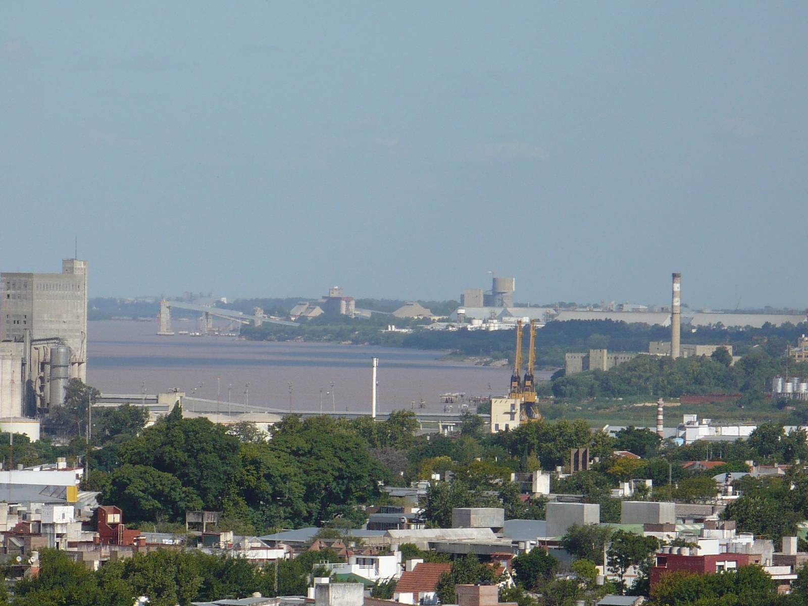 Vista panorámica del puerto de Rosario sobre el río Paraná, con silos de granos, grúas portuarias y la ciudad en primer plano