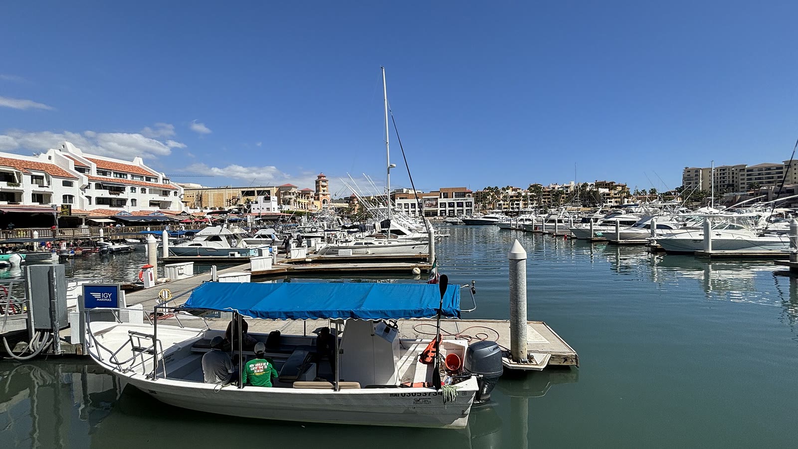 Juego mecánico en Cabo San Lucas: vista de la marina de Cabo San Lucas, Baja California Sur, con lanchas y yates amarrados y edificios al fondo