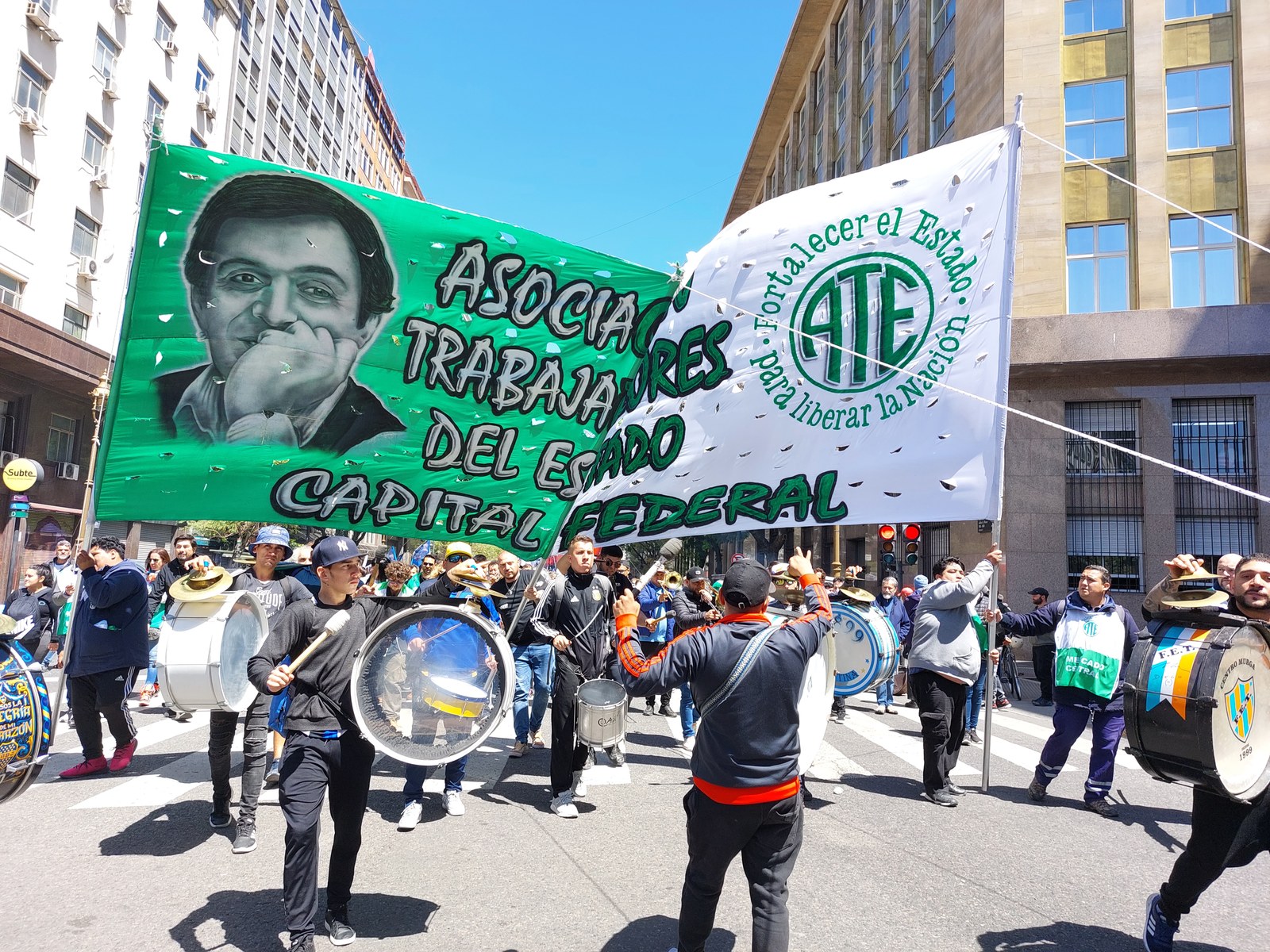 Columna de la Asociación Trabajadores del Estado con bombos y una bandera verde marchando por una avenida porteña en un Día de la Lealtad