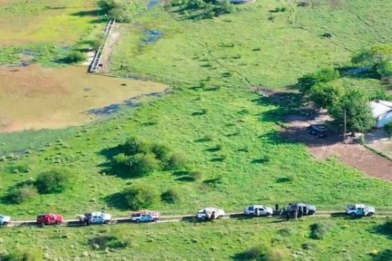 Vista aérea de la búsqueda de Nancy Godoy en la estancia El Curupí, con vehículos policiales en fila